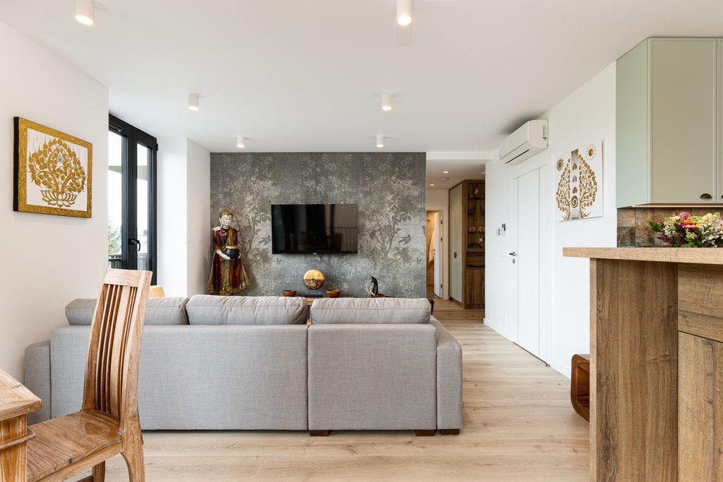 Wohnzimmer der King Suite mit Ecksofa, Wand-TV und gemusterter Tapetenwand